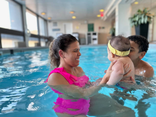 istock Mom playing with kids in the pool 1474045895