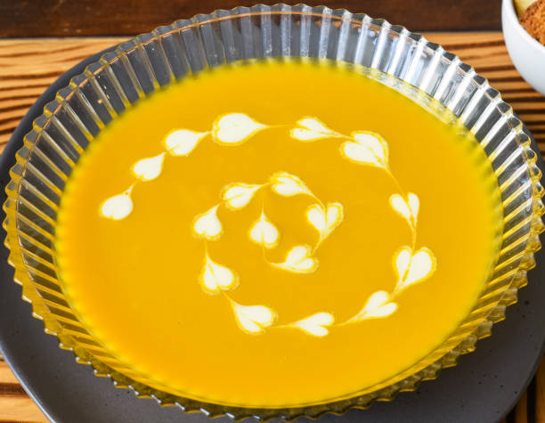 istock Pumpkin Soup on wooden table with crackers side view 1474049682