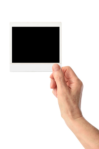 Hand holding blank instant photo card, design template, against white background.\nAdd your own image.