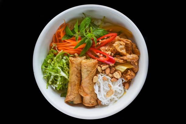 Traditional fried vietnamese spring rolls with pork served with rice noodles, fried beef and peanuts stock photo
