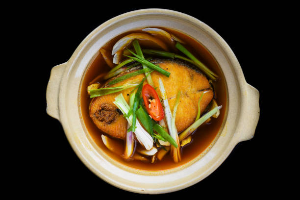 Vietnamese stewed sapa fish in bouillon isolated on black bacground top view stock photo