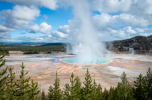 Steam rising from Grand Prismatic Hot Spring, indistinctive tourists walking on the boardwalk. Yellowstone National Park, United States.