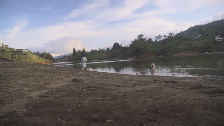 Young woman playing with her pet next to the lake in Peñol Colombia stock video