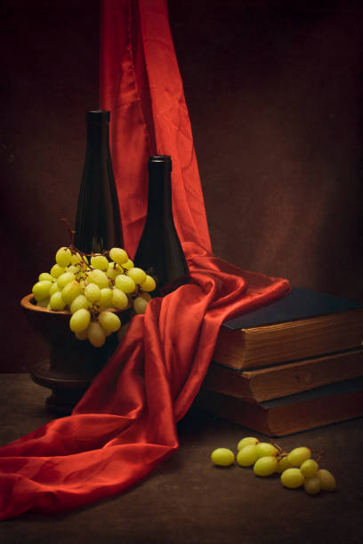 Still life with grapes, old books and bottles
