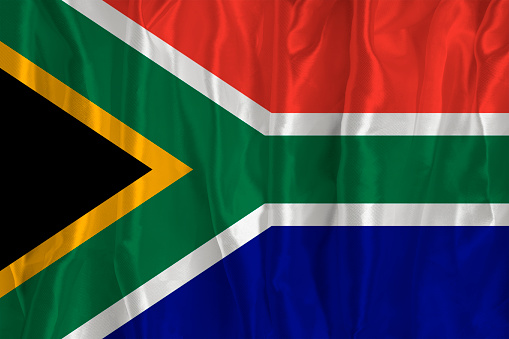 South African flag flies in a strong wind on a pure white background.