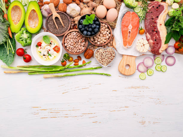 istock Ketogenic low carbs diet concept. Ingredients for healthy foods selection set up on white wooden background. 1474066421