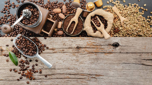 istock Background of various coffee , dark roasted coffee beans , ground and capsules with scoops setup on wooden background with copy space. 1474066574