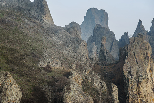 Rocks in Dead city in fog and clouds. Khoba-Tele Ridge of Karadag Reserve in early spring . Crimea