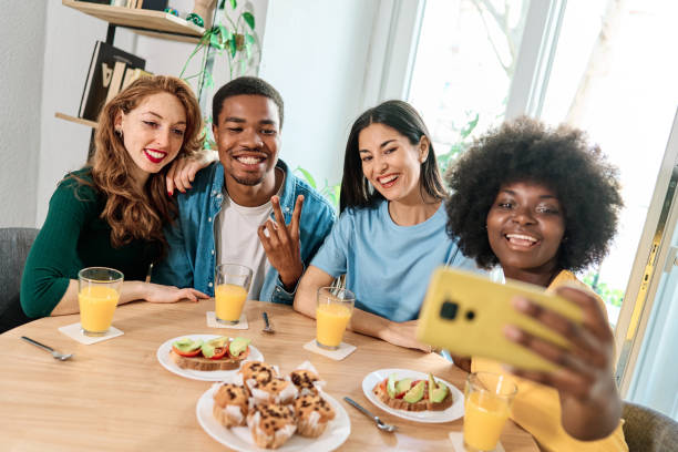 istock Friends talking selfie while gesturing victory indoors 1474068464