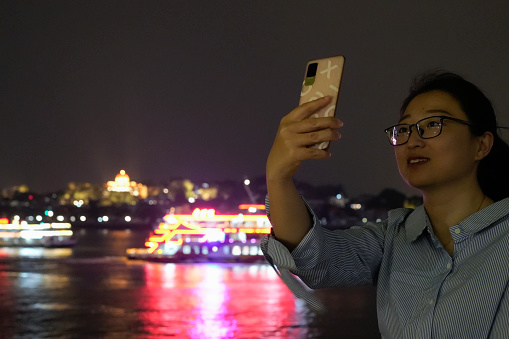 Female tourists take selfies on the seawall