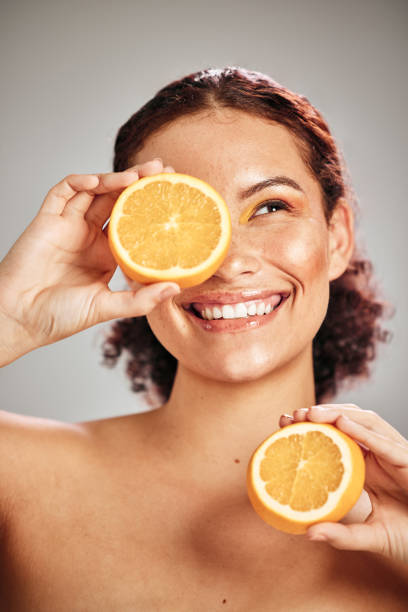 Orange, beauty and woman face in studio with a smile for natural skin glow, cosmetic and dermatology. Facial results, health and wellness of aesthetic model person happy with vitamin c fruit idea Orange, beauty and woman face in studio with a smile for natural skin glow, cosmetic and dermatology. Facial results, health and wellness of aesthetic model person happy with vitamin c fruit idea vitamin c stock pictures, royalty-free photos & images