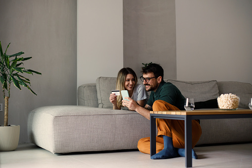 Shot of a young couple using a digital tablet and credit card on the sofa at home