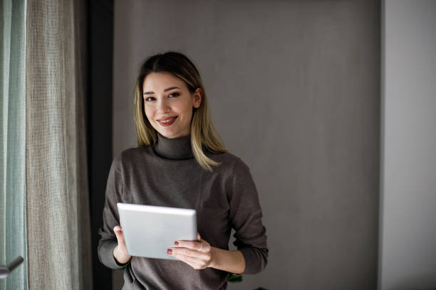istock Happy woman manager holding tablet and standing 1474075514