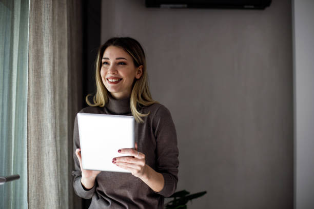 istock Happy woman manager holding tablet and standing 1474075515