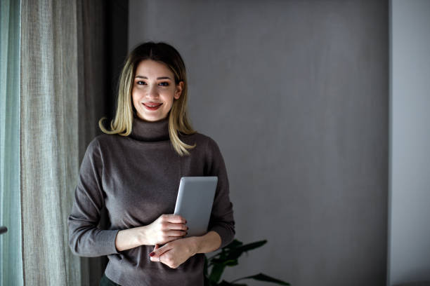 istock Happy woman manager holding tablet and standing 1474075521