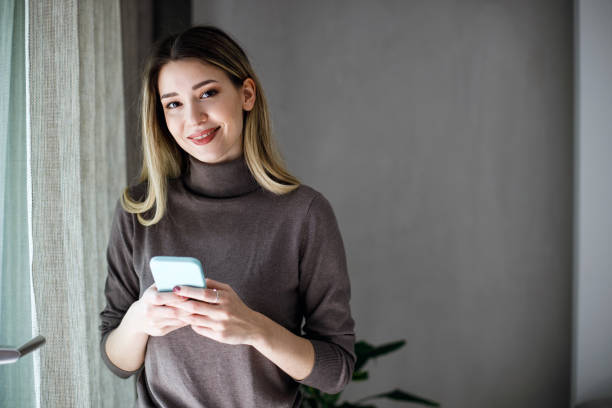 istock Smiling young woman using cellphone. 1474075530