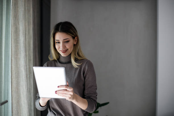 istock Happy woman manager holding tablet and standing 1474075559