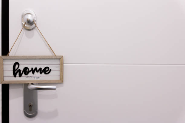 istock Home sign hanging on a white door. 1474077692