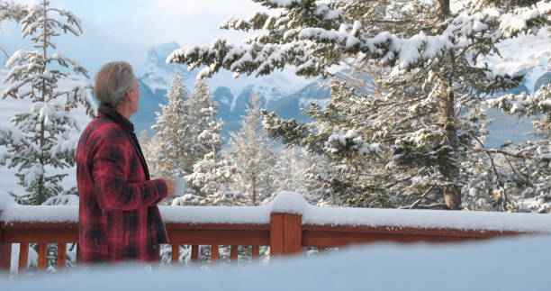 istock Mature man enjoys hot drink on cabin veranda 1474077747