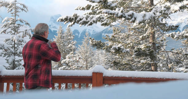 istock Mature man enjoys hot drink on cabin veranda 1474077749