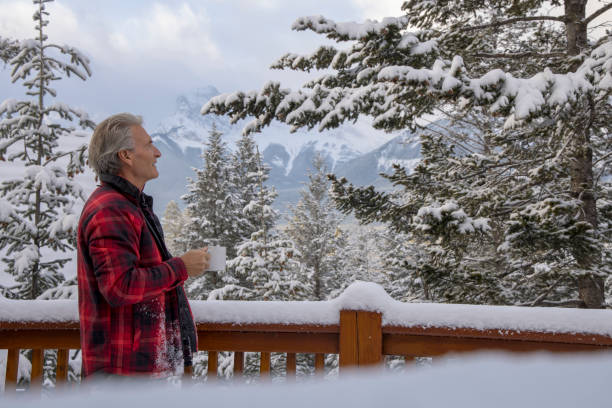 istock Mature man enjoys hot drink on cabin veranda 1474077757