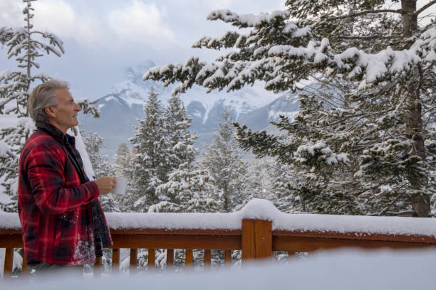 istock Mature man enjoys hot drink on cabin veranda 1474077774