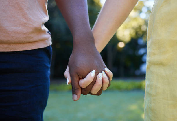 istock Interracial, couple holding hands and trust, love outdoor in nature and commitment, support in relationship. Together in park, black man with woman, hand zoom and care, romantic date with partnership 1474078124