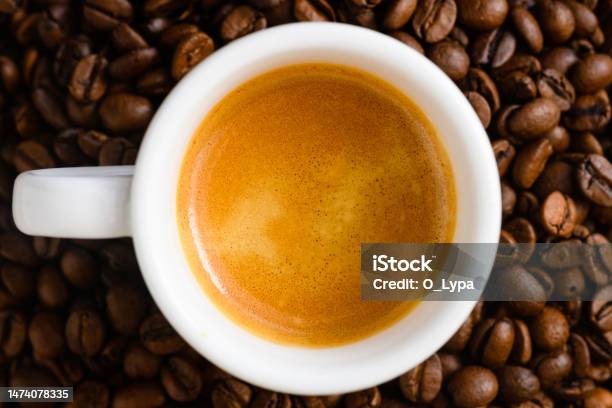 Top View Of Brewed Espresso In A Cup At Whole Roasted Coffee Beans Background Stock Photo - Download Image Now