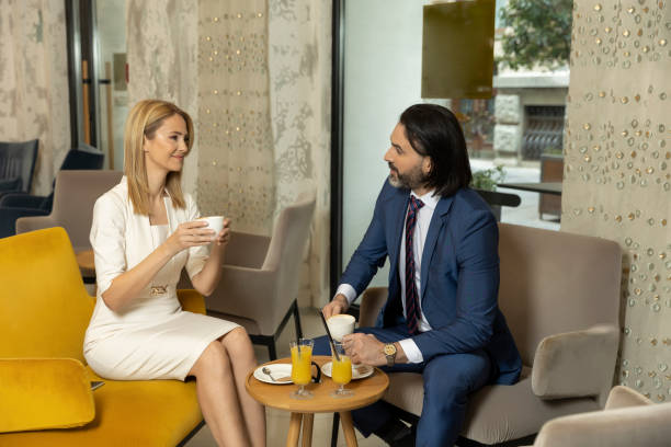 istock Business couple drinking coffee in hotel lobby 1474078920