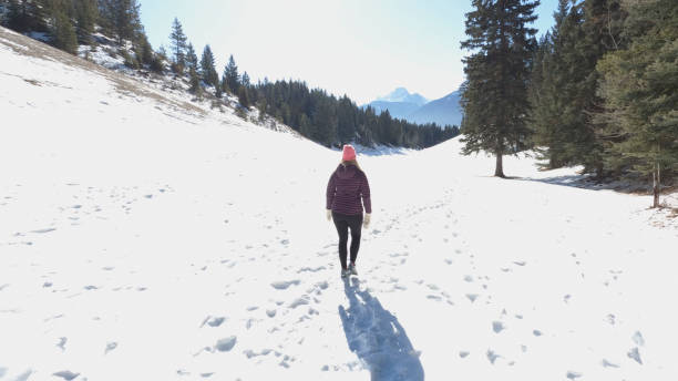 istock Mature couple walk along snowy path in mountain  setting 1474082021