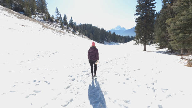 istock Mature couple walk along snowy path in mountain  setting 1474082023