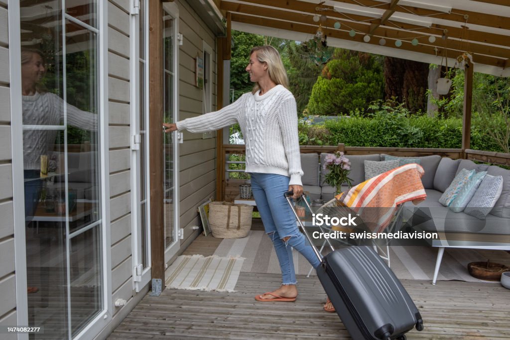 Woman arriving at her vacation rental cabin Cabin getaway Vacation Rental Stock Photo