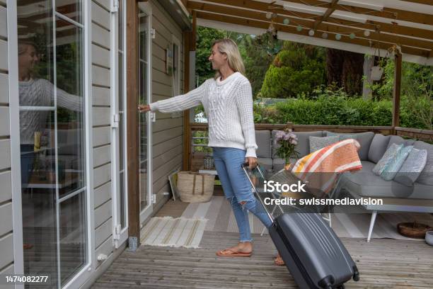Woman Arriving At Her Vacation Rental Cabin Stock Photo - Download Image Now - Vacation Rental, Renting, Suitcase