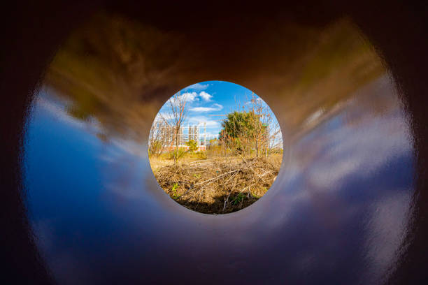 Shiny metal culvert with spiral pattern going from light to dark.