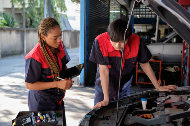 istock Two automotive mechanical partners check an EV car at a fixing garage. 1474084499