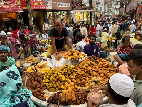Dhaka, Bangladesh – April 16, 2022: Traditional Ifter Market in Old Town Dhaka, Bangladesh. When Ramadan begins, Chawkbazar becomes one of the busiest places in the city. This market offers a tantalising mix of meat dishes, some of which have Mughal roots, according to locals.