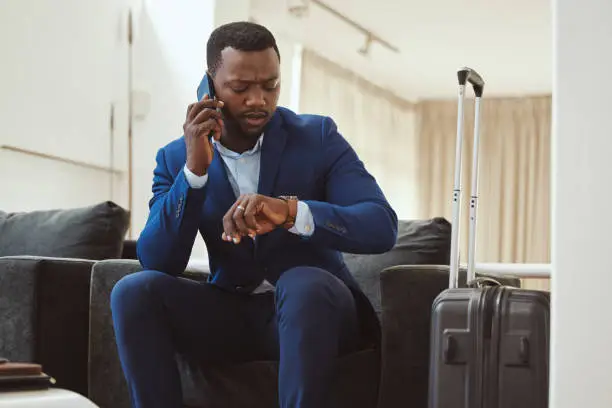 African businessman, checking time in hotel and phonecall for work travel schedule in Atlanta. Young black entrepreneur speaking on cellphone, professional time management or luxury airport travel