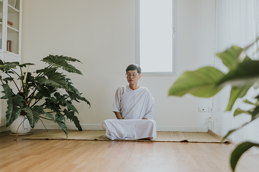 Retirement person meditate at home, morning routine of retirement person.