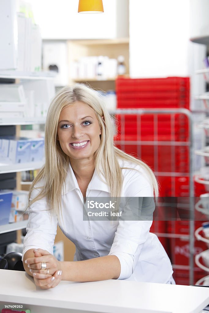 Sorrindo feminino Farmacêutico no balcão - Foto de stock de Farmacêutica royalty-free