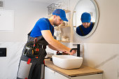 Jack of all trades repairs the faucet in the bathroom. The concept of maintenance and home help