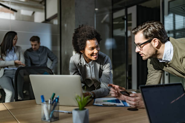 istock Happy business colleagues talking while working at casual office. 1474093910