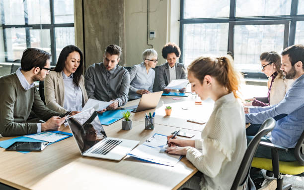 istock Large group of entrepreneurs working on reports in the office. 1474094219