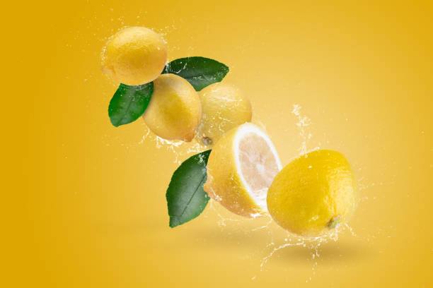 istock Water Splashing yellow lemon fruit on a yellow background. 1474095568