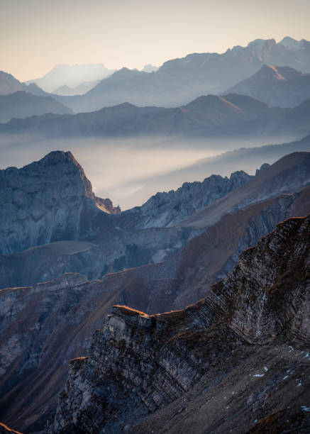 istock Cold bluish mountain landscape in fog at sunrise 1474099414
