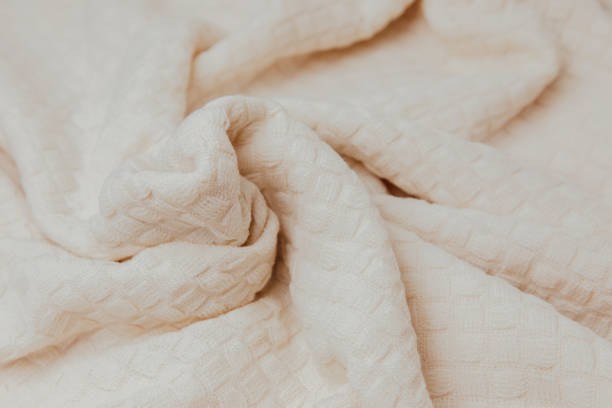 istock Textured background for design. Light beige knitted fabric with a checkered pattern 1474099906
