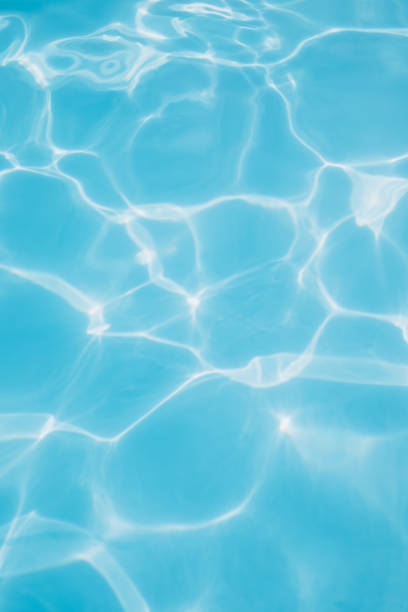 istock Background, blue water waves in the pool with sun reflection. Selective focus 1474099929