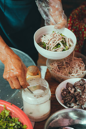 indigenous senior woman cooking Pho soup at market in Bac ha, Vietnam