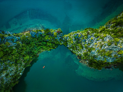 Drone view on rocks and canoes floating on turquoise water in the Halong Bay, Vietnam