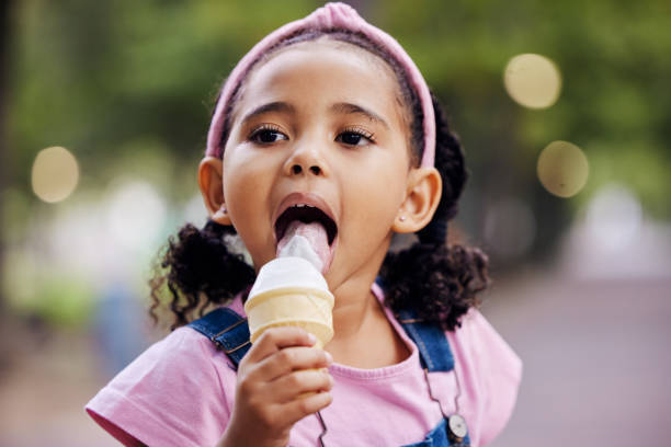 Young girl, face and eating ice cream in park, outdoor in nature with family day and dessert at picnic. Summer vacation, fun trip and gelato with kid, relax and freedom, travel and adventure mockup Young girl, face and eating ice cream in park, outdoor in nature with family day and dessert at picnic. Summer vacation, fun trip and gelato with kid, relax and freedom, travel and adventure mockup licking ice cream cone stock pictures, royalty-free photos & images