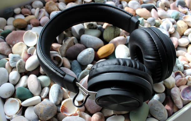istock Modern Headphones On A Smooth Sea Rocks And Shells Angle View 1474101796